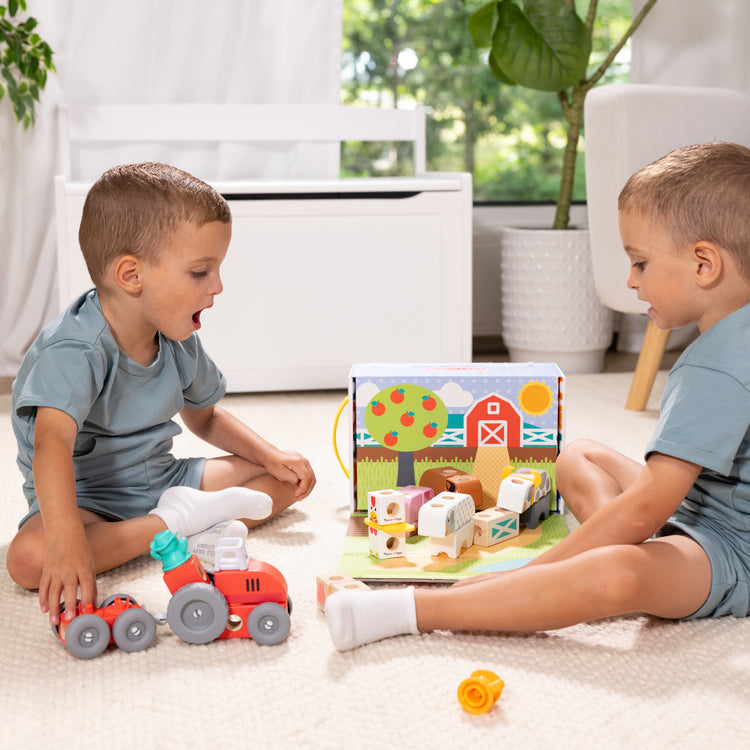 A kid playing with The Melissa & Doug Blockables™ Farm Snap And Play, Mix And Match Connectable Wooden Building Blocks Play Set Toy for Preschool Boys And Girls (56 Pcs)
