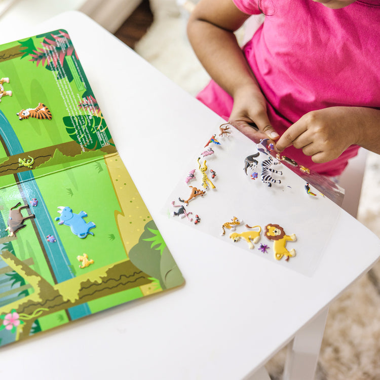 A kid playing with The Melissa & Doug Puffy Sticker Activity Books Set - Farm, Safari, and Chipmunk