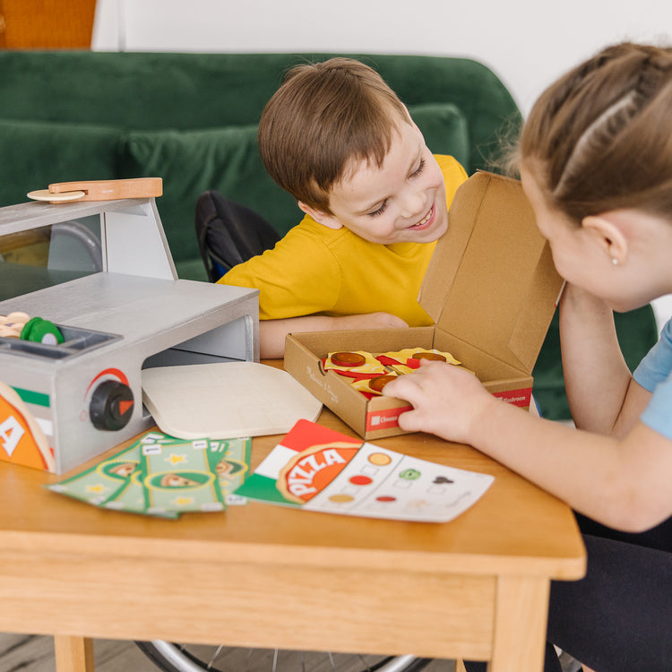 A kid playing with The Melissa & Doug Top & Bake Wooden Pizza Counter Play Set with Play Food (41 Pcs) Preschool Toy