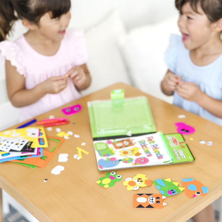 A kid playing with The Melissa & Doug On the Go Felt Friends Craft Activity Set With 188 Felt Stickers