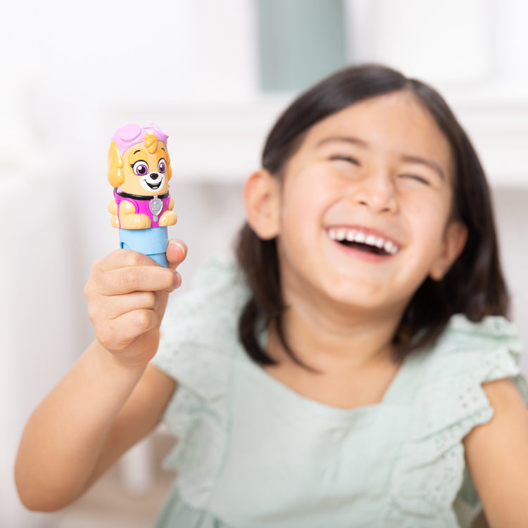 A kid playing with The Melissa & Doug Sticker WOW!™ PAW Patrol Skye Bundle: 24-Page Activity Pad, Sticker Stamper, 500 Stickers, Mini Pad, Arts and Crafts Fidget Toy Collectible Character