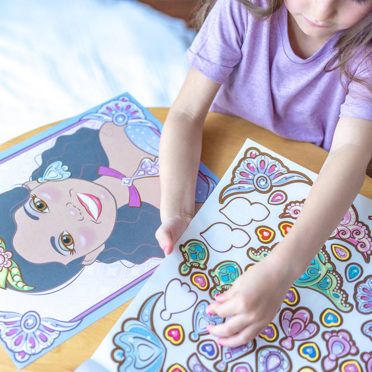 A kid playing with The Melissa & Doug Make-a-Face Sticker Pad: Sparkling Princesses - 15 Faces, 4 Sticker Sheets