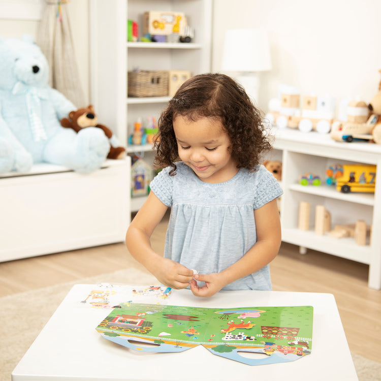 A kid playing with The Melissa & Doug Puffy Sticker Activity Books Set - Farm, Safari, and Chipmunk