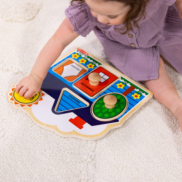 Girl playing with Melissa & Doug knob puzzle