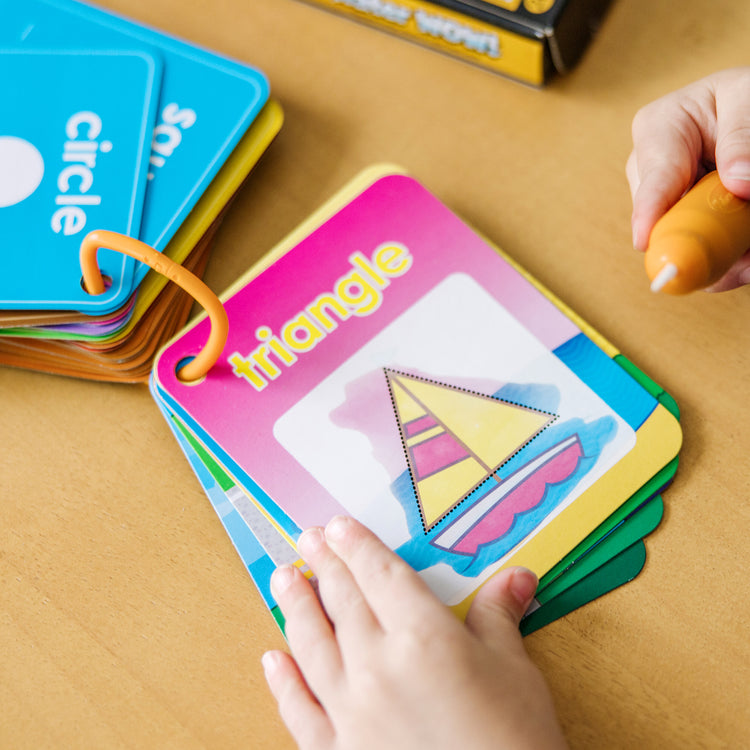 A kid playing with The Doug On the Go Water Wow! Reusable Water-Reveal Cards - Shapes, Numbers, Colors