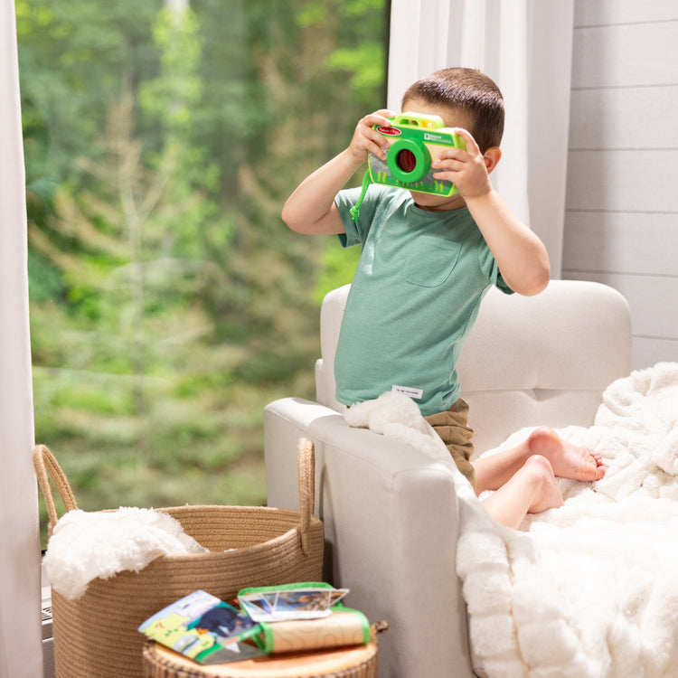 A kid playing with The Melissa & Doug Rocky Mountain National Park Sights and Sounds Wooden Toy Camera Play Set