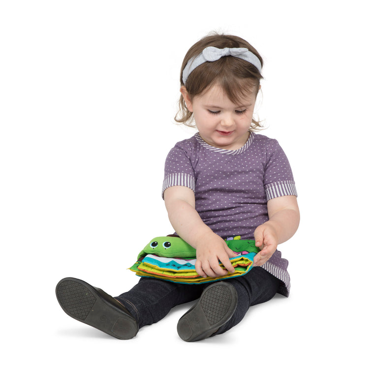 A child on white background with The Melissa & Doug Soft Activity Baby Book - Whose Feet?