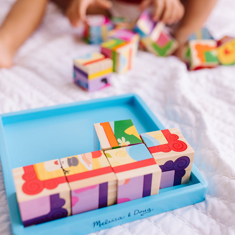 A kid playing with The Melissa & Doug Blue's Clues & You! Wooden Cube Puzzle (16 Pieces)