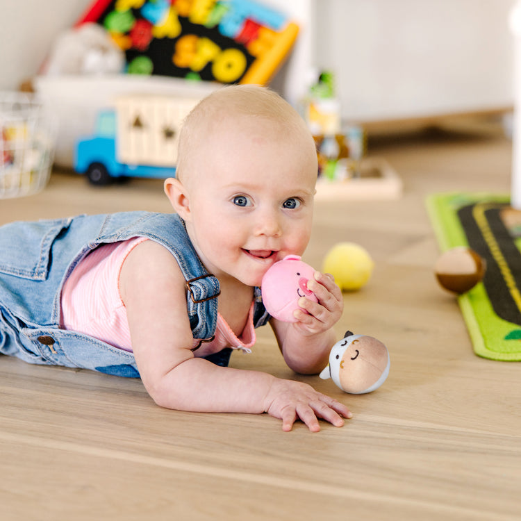 A kid playing with The Melissa & Doug Rollables Farm Friends Infant and Toddler Toy (4 Pieces)