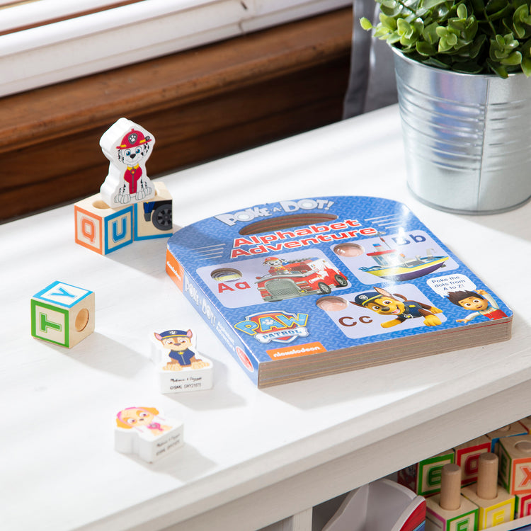 A playroom scene with The Melissa & Doug PAW Patrol Children's Book - Poke-A-Dot: Alphabet Adventure