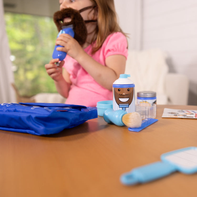 A kid playing with The Melissa & Doug Barber Shop Pretend Play Set Shaving Toy for Boys and Girls Ages 3+