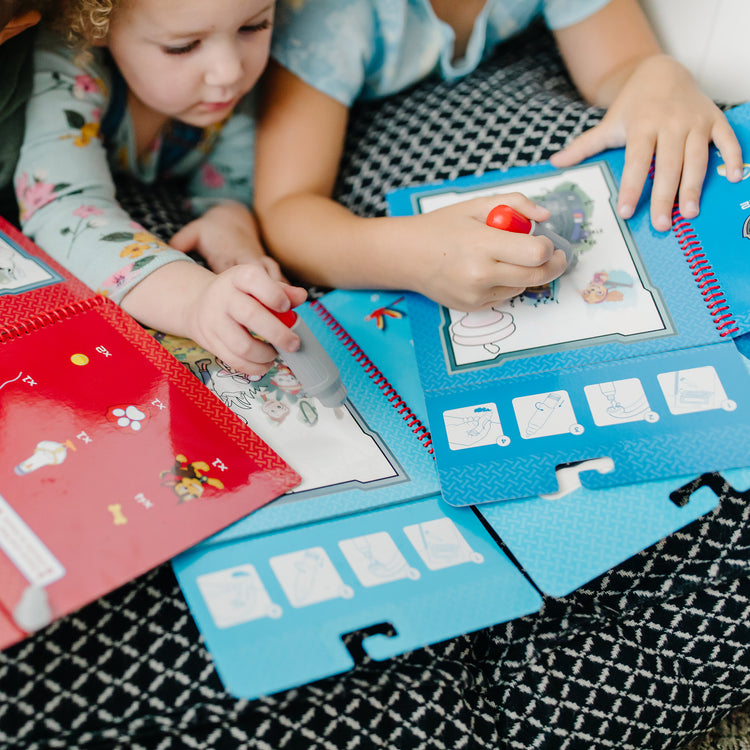 A kid playing with The Melissa & Doug PAW Patrol Water Wow! - Skye Water Reveal Travel Activity Pad