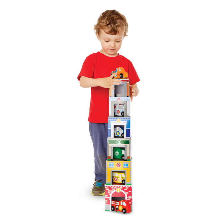 A kid playing with The Melissa & Doug Nesting and Sorting Blocks - 6 Buildings, 6 Wooden Vehicles