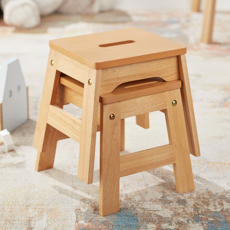 A playroom scene with The Melissa & Doug Wooden Stools – Set of 2 Stackable, Portable 11-Inch-Tall Stools (Natural)