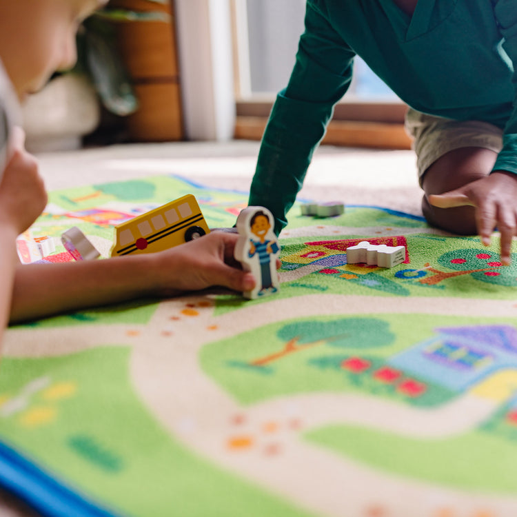 A kid playing with The Melissa & Doug Blue's Clues & You! Blue's Neighborhood Activity Rug (44 Inches x 26 Inches Rug, 9 Wooden Play Pieces)