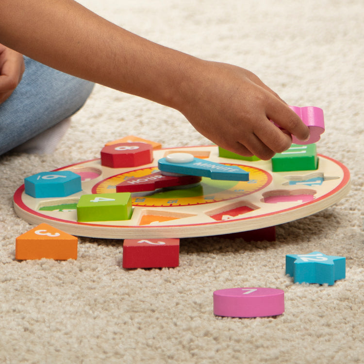 A kid playing with The Melissa & Doug Shape Sorting Clock - Wooden Educational Toy