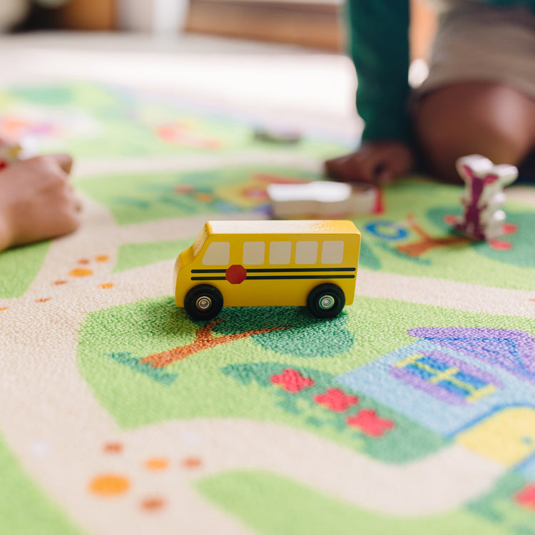 A kid playing with The Melissa & Doug Blue's Clues & You! Blue's Neighborhood Activity Rug (44 Inches x 26 Inches Rug, 9 Wooden Play Pieces)