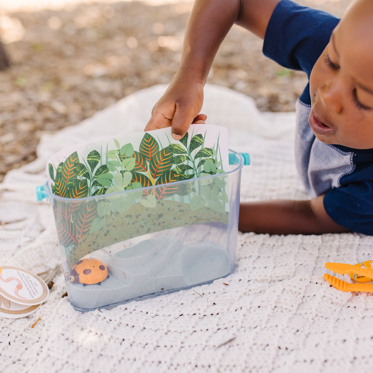 A kid playing with The Melissa & Doug Let’s Explore Terrarium Observations Play Set (16 Pieces)