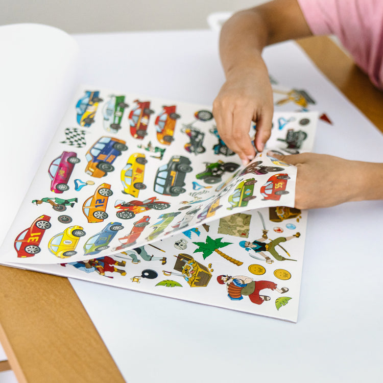 A kid playing with The Melissa & Doug Sticker Collection Book: Dinosaurs, Vehicles, Space, and More - 500+ Stickers