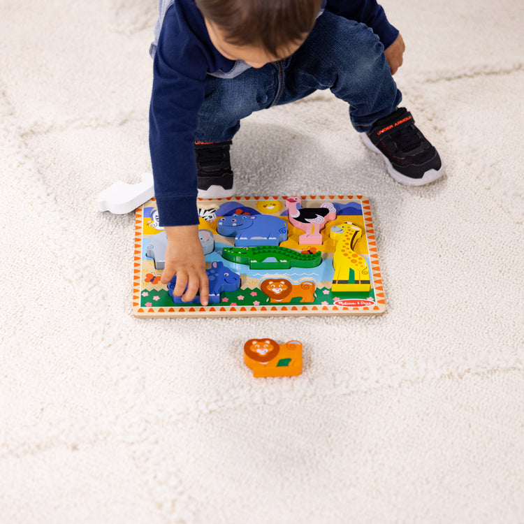 A kid playing with The Melissa & Doug Safari Wooden Chunky Puzzle - 8 Pieces