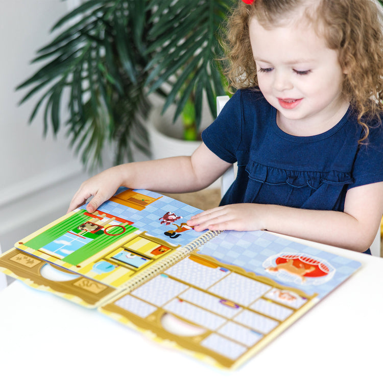 A kid playing with The Melissa & Doug Pet Shop Puffy Sticker Set With 115 Reusable Stickers