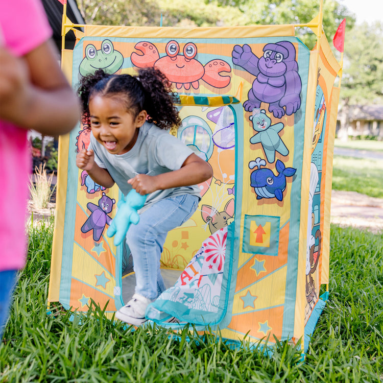 A kid playing with The Melissa & Doug Fun at the Fair! Game Center Play Tent – 4 Sides of Activities