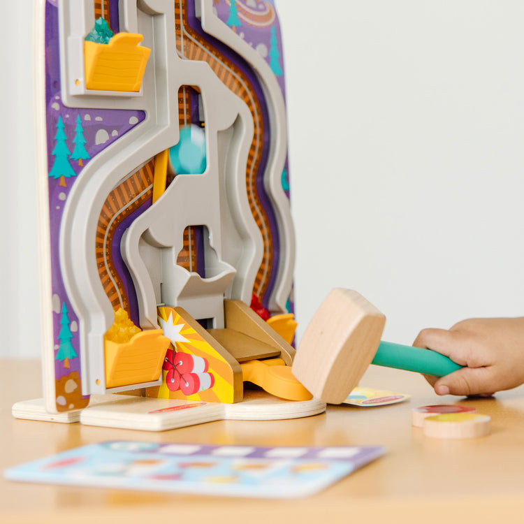 A kid playing with The Melissa & Doug Fun at the Fair! Wooden Ring the Bell Game