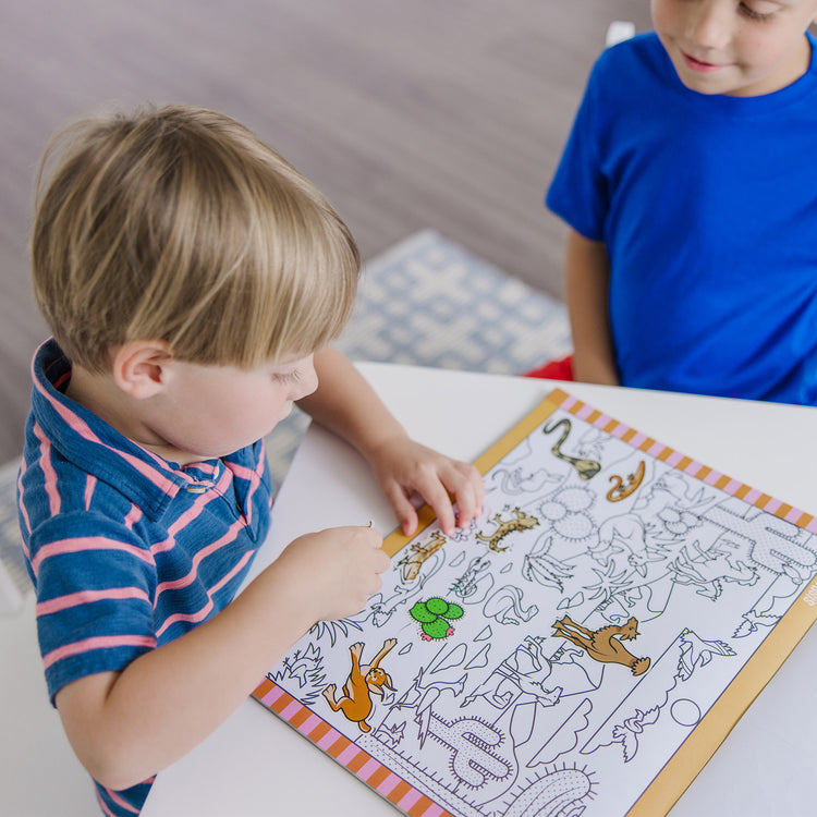 A kid playing with The Melissa & Doug Seek and Find Sticker Pad, Animals (400+ Stickers, 14 Scenes to Color)