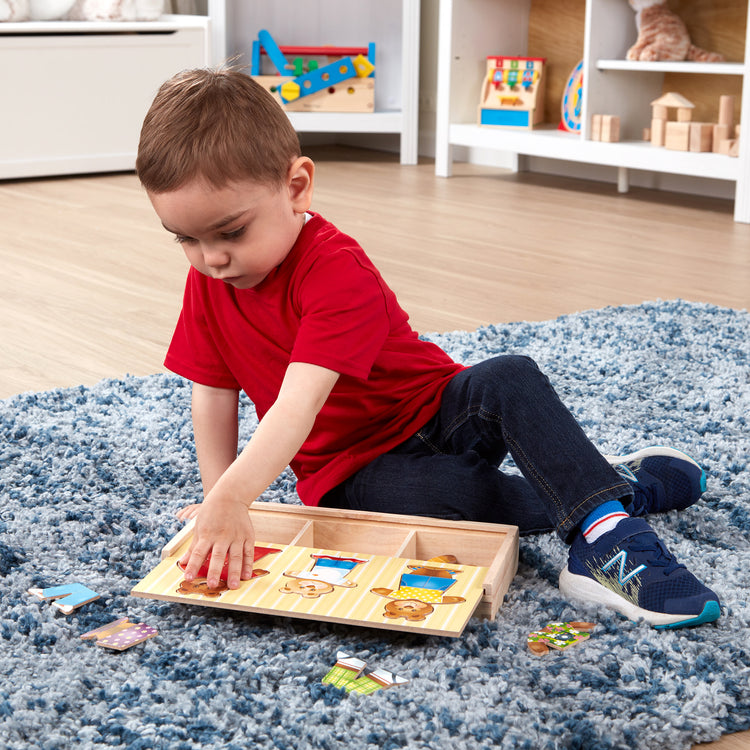 A kid playing with The Melissa & Doug Mix 'n Match Wooden Bear Family Dress-Up Puzzle With Storage Case (45 pcs)