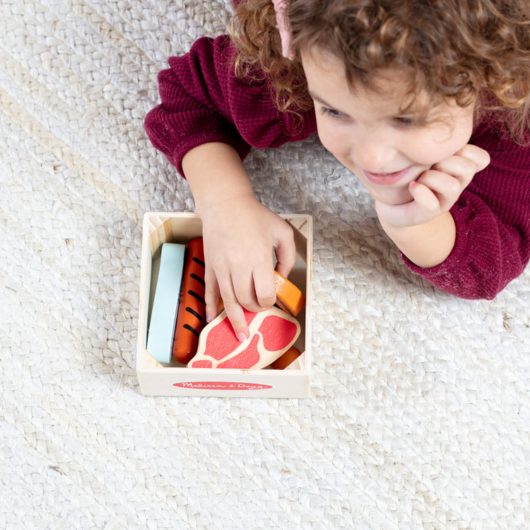 A kid playing with The Melissa & Doug Wooden Food Groups Play Food Set – Protein