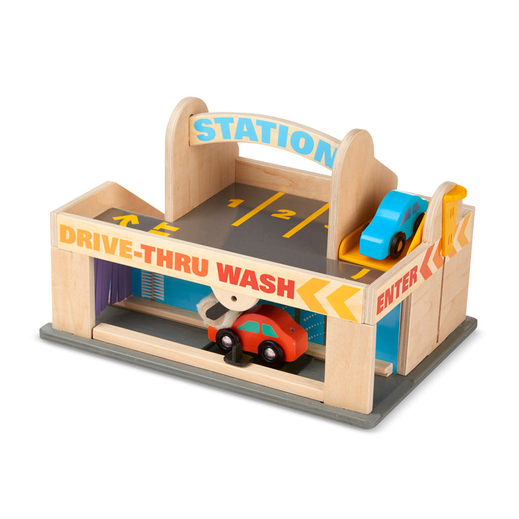 The loose pieces of The Melissa & Doug Service Station Parking Garage With 2 Wooden Cars and Drive-Thru Car Wash