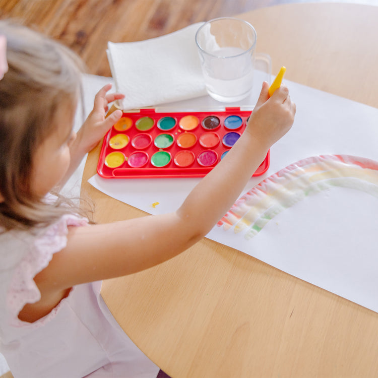 A kid playing with The Melissa & Doug Tabletop Easel Paper Roll (12 inches x 75 feet) - 2-Pack