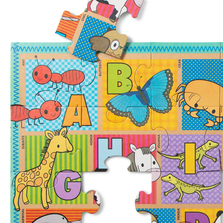 The loose pieces of The Melissa & Doug Natural Play Giant Floor Puzzle: ABC Animals (35 Pieces)