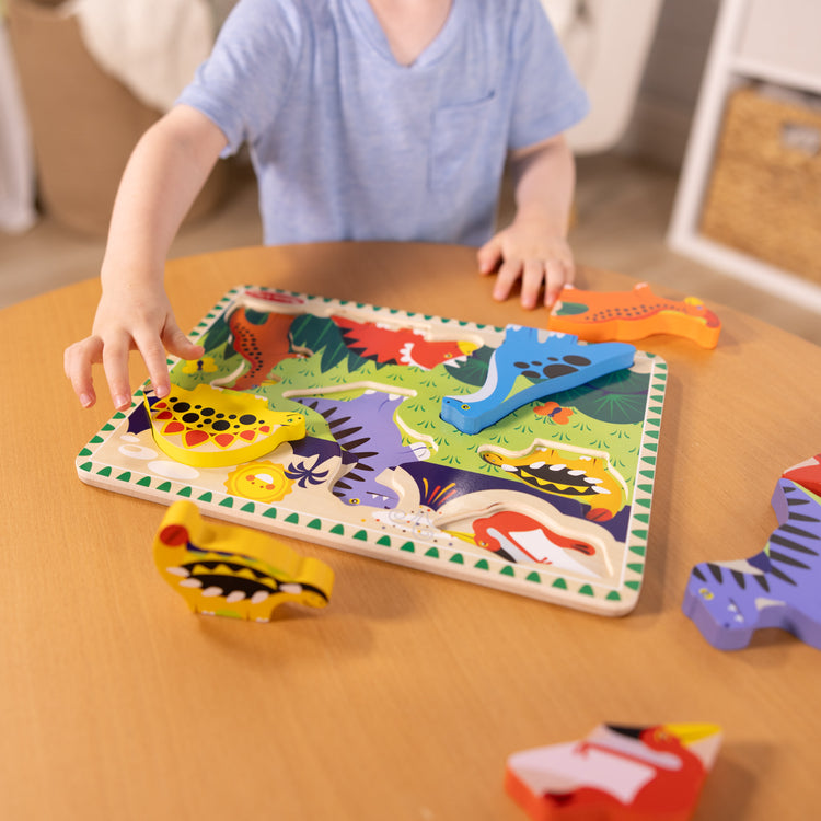 A kid playing with The Melissa & Doug Dinosaur Wooden Chunky Puzzle (7 pcs)