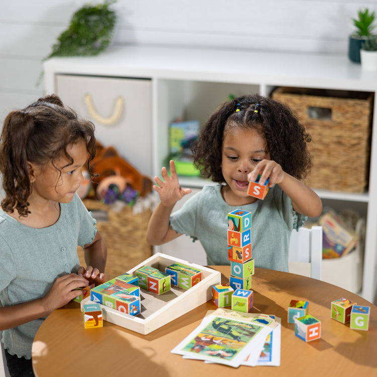 A kid playing with The Melissa & Doug National Parks Alphabet & Animals 24-Piece Cube Puzzle (Everglades, Arches, Yellowstone)