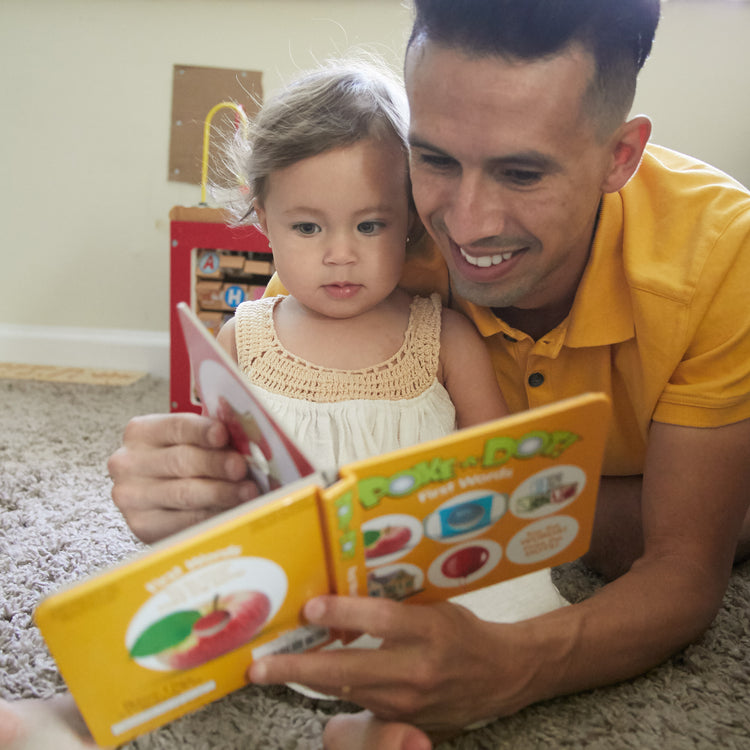 A kid playing with The Melissa & Doug Children’s Book – Poke-a-Dot: First Words (Board Book with Buttons to Pop)