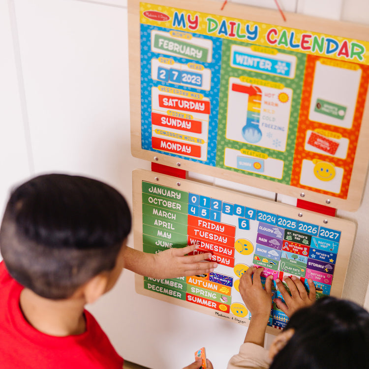 A kid playing with The Melissa & Doug My First Daily Magnetic Calendar