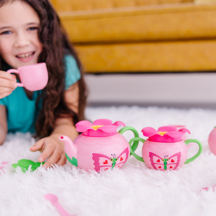 A kid playing with The Melissa & Doug Butterfly Tea Set (15 pcs) - Play Food Accessories