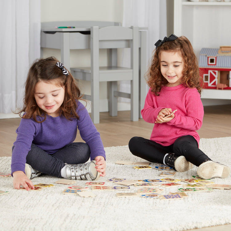 A kid playing with The Melissa & Doug Self-Correcting Wooden Number Puzzles With Storage Box (40 pcs)