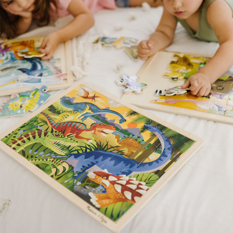 A kid playing with The Melissa & Doug Jigsaw Puzzle Bundle (Dinosaur,Safari and Ocean)