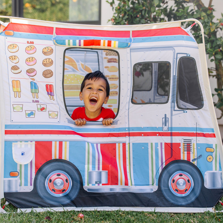 A kid playing with The Melissa & Doug Fabric Double-Sided Food Truck Play Tent - Ice Cream And BBQ