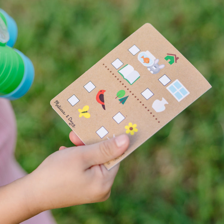 A kid playing with The Melissa & Doug Let's Explore Binoculars & Compass Play Set