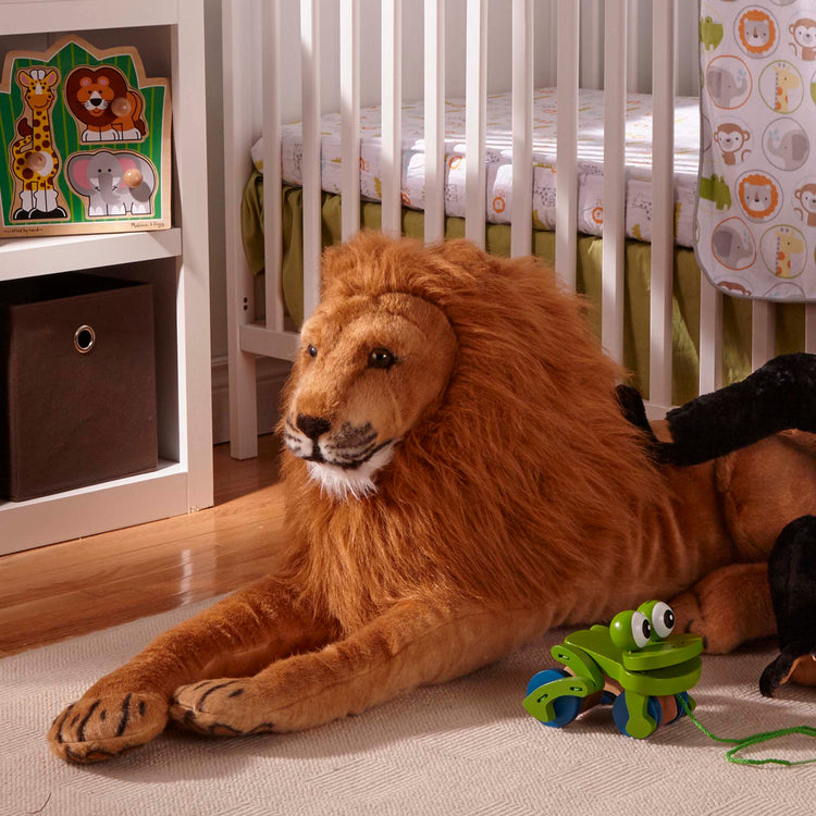 A kid playing with The Melissa & Doug Giant Lion - Lifelike Stuffed Animal (over 6 feet long)