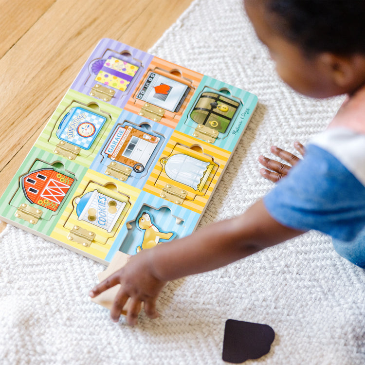 A kid playing with The Melissa & Doug Hide and Seek Wooden Activity Board With Wooden Magnets