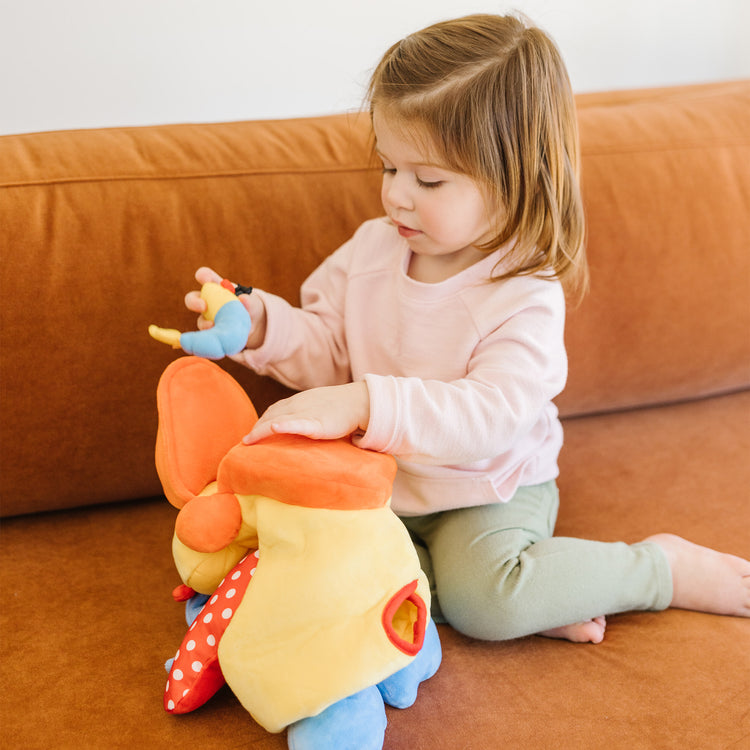 A kid playing with The Melissa & Doug K's Kids Hungry Pelican Soft Baby Educational Toy