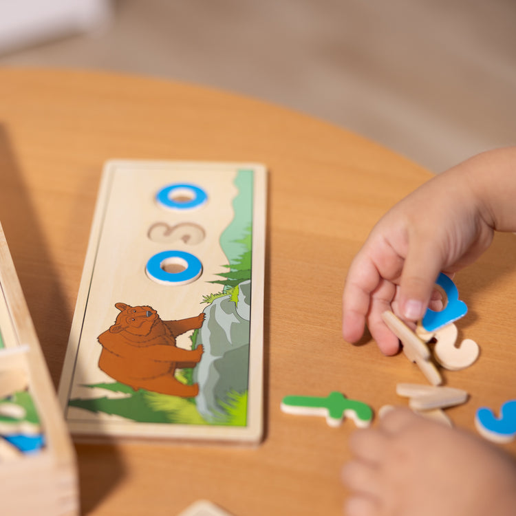 A kid playing with The Melissa & Doug Spanish See & Spell Educational Language Learning Toy