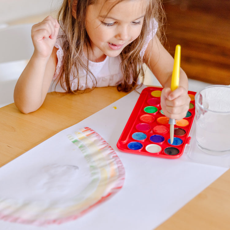 A kid playing with The Melissa & Doug Tabletop Easel Paper Roll (12 inches x 75 feet) - 2-Pack