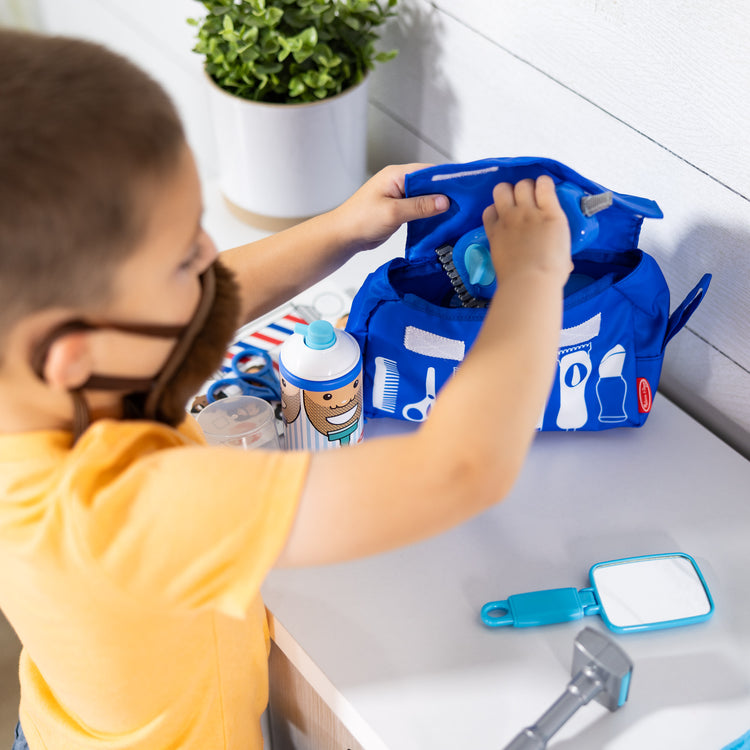 A kid playing with The Melissa & Doug Barber Shop Pretend Play Set Shaving Toy for Boys and Girls Ages 3+