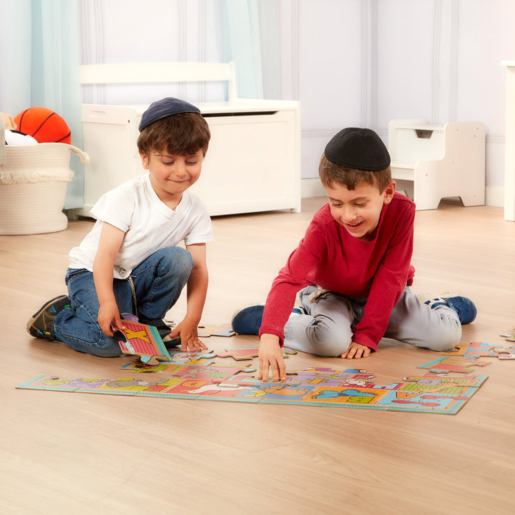 A kid playing with The Melissa & Doug Natural Play Giant Floor Puzzle: ABC Animals (35 Pieces)