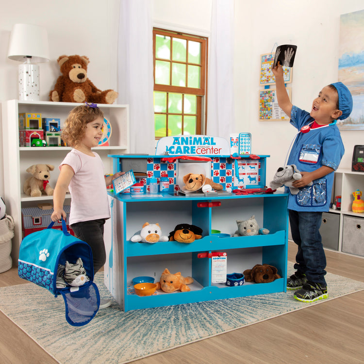 A kid playing with The Melissa & Doug Animal Care Veterinarian and Groomer Wooden Activity Center for Plush Stuffed Pets (Not Included)